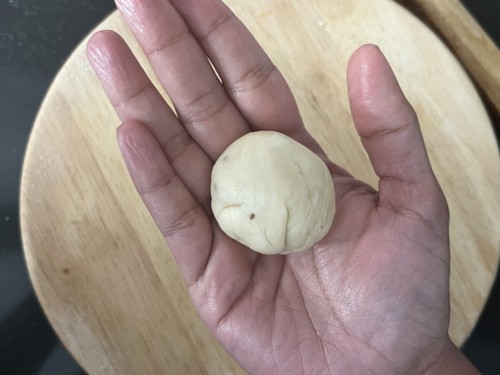 A hand holding a ball of dough.