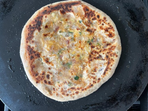 A cooked paratha in a tawa.