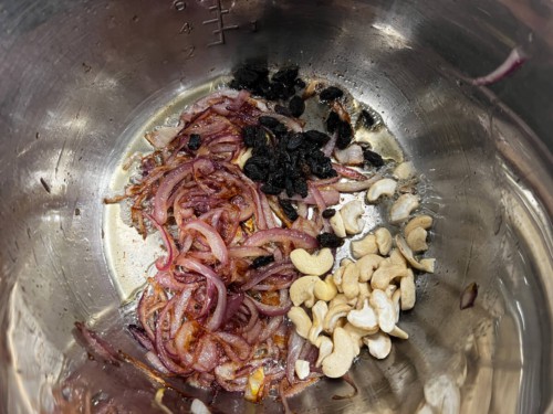 Adding onions and cashews to ghee.