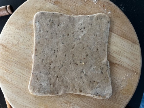 The paratha dough is rolled into a neat square.