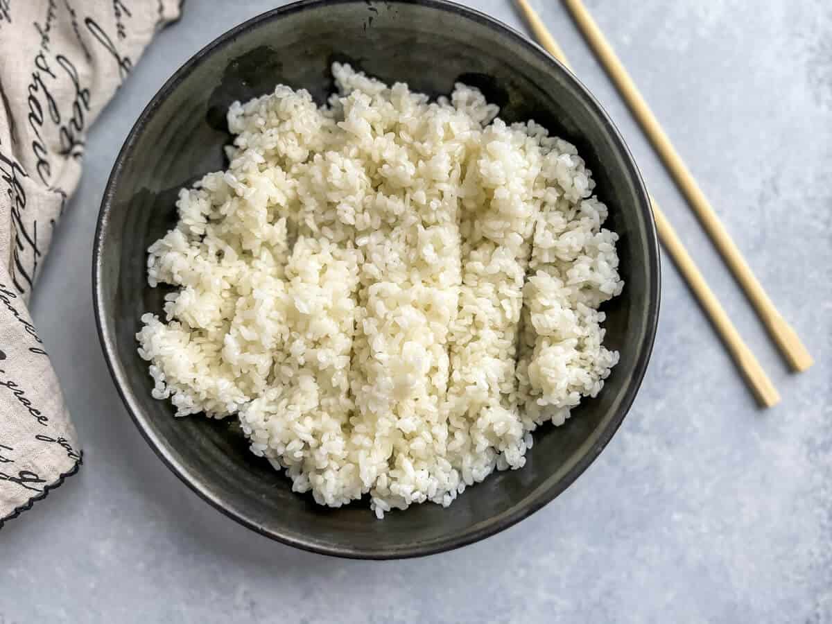 Horizontal view of fluffy sushi rice in a bowl.