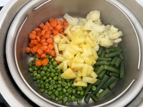 Steamed veggies in the Instant Pot: diced carrots, cauliflower, green beans, peas, and potatoes.