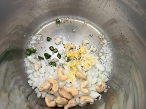 Raw cashews and onions in an Instant Pot.