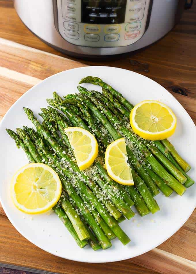 Asparagus served on a white plate with lemon slices