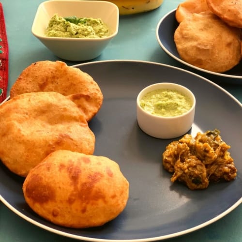 Mangalore buns served with two chutneys in a blue plate