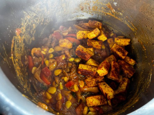 Paneer with vegetables in a pressure cooker.