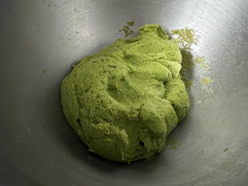 Spinach dough formed in metal bowl.