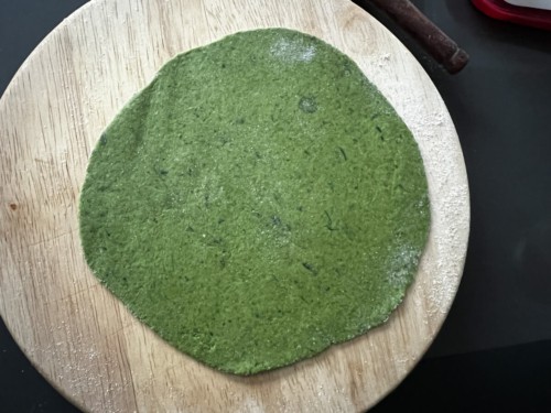 Dough rolled out into green circle.