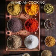 10 spices / spice powders in glass bowls with caption Essential Spices in Indian Cooking