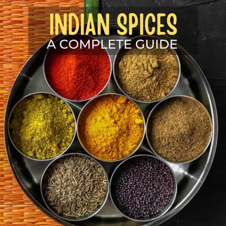 7 essential Indian spices in a steel spice box with caption Indian spices - a complete guide!