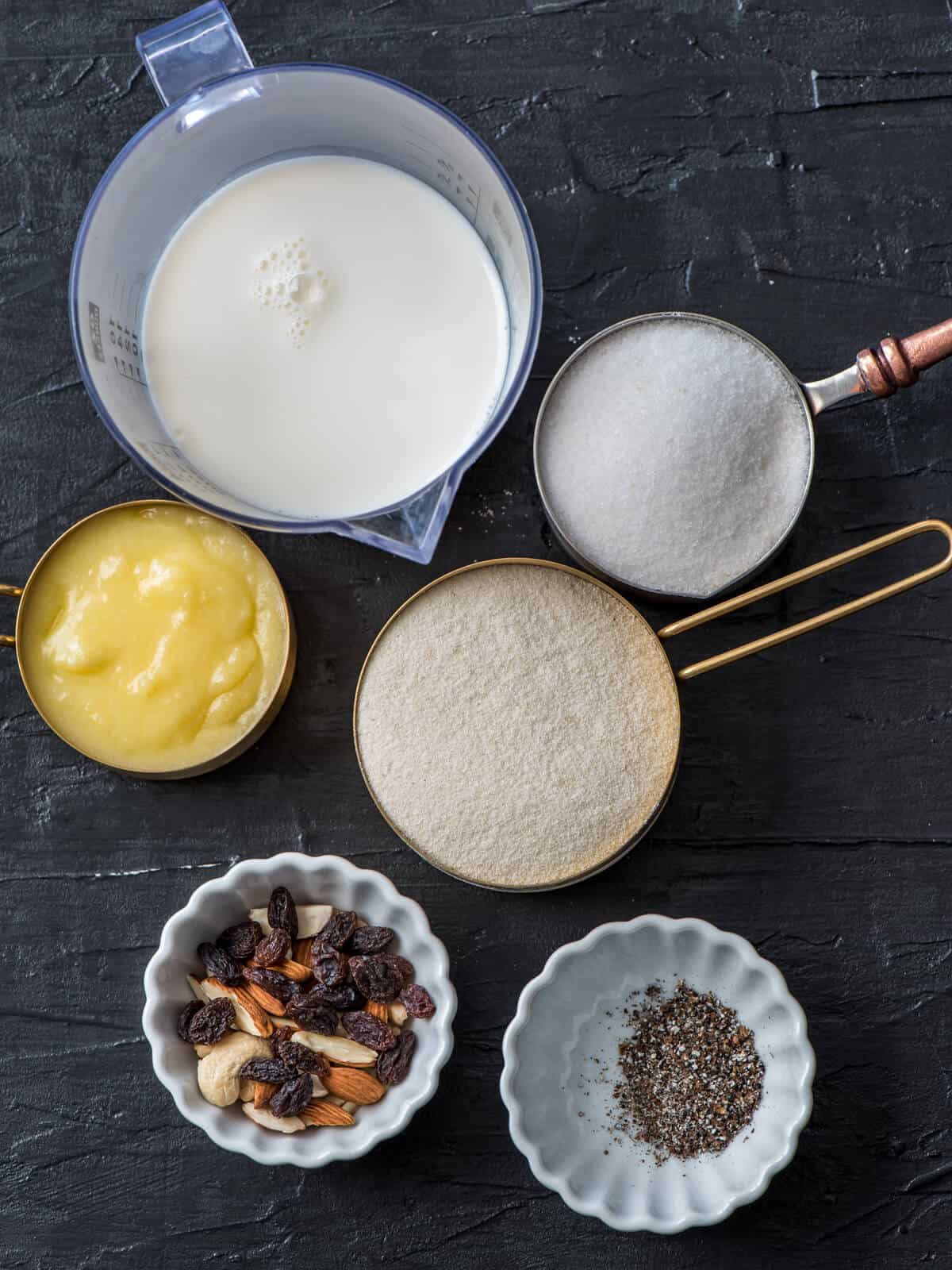 Ingredients for sooji halwa - semolina, cardamom powder, nuts, ghee, sugar and milk