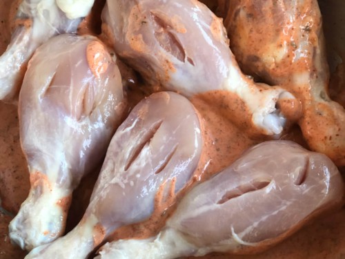Slits cut into chicken placed in a marinade